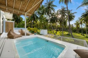 an indoor pool on a patio with palm trees at Baan Boho Villas in Ko Phangan