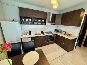 a kitchen with wooden cabinets and a table with a table sidx sidx at Misa Home in Nyíregyháza
