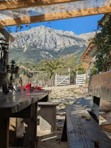 a wooden picnic table with a mountain in the background at Αγρόκτημα Agrikia Σπίτι in Arachova