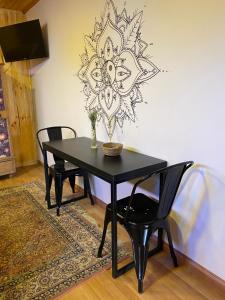 a black table and chairs in a room with a mandala wall at Hermoso Loft Amoblado Sector Oriente Talca in Talca