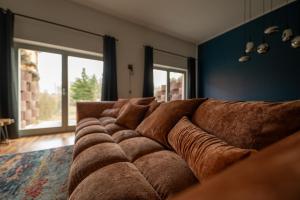 a large brown couch in a living room at Fabrik68 - ganzes Haus 3 Schlafzimmer 2 Bäder in Peitz +36 photos