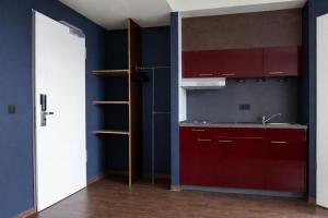 a kitchen with red cabinets and a sink at Base Apartments in Hamburg