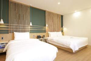 two beds sitting next to each other in a bedroom at 스테이 공담호텔 in Kyū-masan