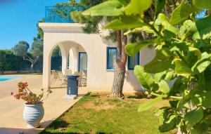 a house with a patio and a tree in the yard at Azzurro Holiday Villas in Peyia