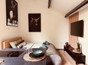 a living room with a table and a cow on the wall at TINY HOUSE - La cabane de Tom in Blaimont