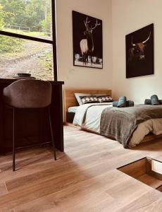 a bedroom with a bed and a large window at TINY HOUSE - La cabane de Tom in Blaimont