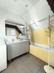 a bathroom with a sink and a bath tub at Superbe duplex « le Grévy » in Dole