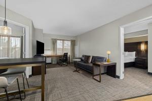 a hotel room with a couch and a bed at Residence Inn Paducah in Paducah