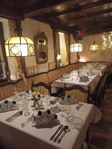 a row of tables in a restaurant with white table settings at Hotel Pfaff in Triberg