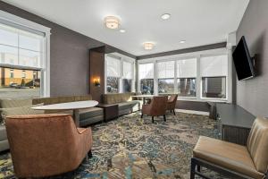 a waiting room with chairs and a table and windows at Residence Inn Paducah in Paducah