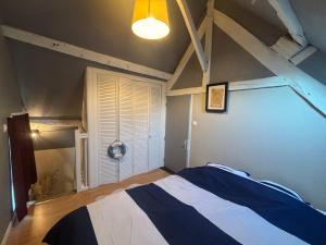 a bedroom with a bed with a blue and white blanket at Maison in Verneuil-en-Halatte