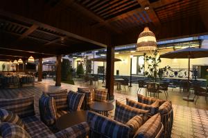 a restaurant with couches and tables and umbrellas at Mercure Tashkent North in Tashkent