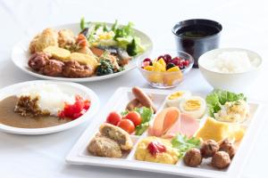 a white table with plates of food and bowls of food at Urbain Hiroshima Central in Hiroshima