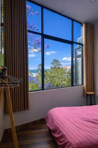 a bedroom with a large window with a pink bed at Salem House in Da Lat