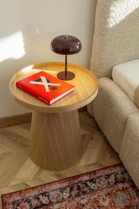 a table with a book on it next to a couch at ATRIUM City Center Apartment in Kaunas