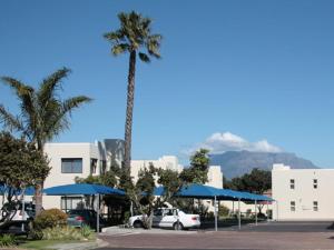 a palm tree in a parking lot with mountains in the background at Amies Self-Catering Apartments in Panorama
