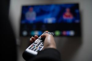 Eine Person hält eine Fernbedienung vor einem Fernseher. in der Unterkunft Rest Inn Edmonton in Edmonton + 51 Fotos