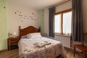 a bedroom with a bed and a window with birds on the wall at Hostal La Balsá in La Alberca