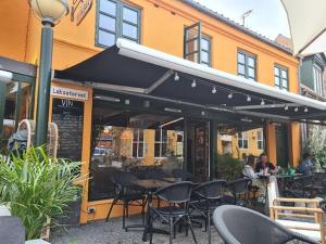 a restaurant with tables and chairs in front of a building at Hotel Sniva in Rønne