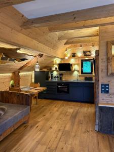a large kitchen with wooden walls and wooden floors at Bergromantik Ferienwohnung Charisma mit eigener Sauna, Whirlpool und Bergblick in Marktschellenberg