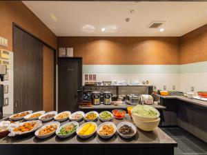 a buffet with many bowls of food on a table at MyHotel Okazaki in Okazaki