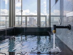 a hot tub in a building with a view of the city at MyHotel Okazaki in Okazaki