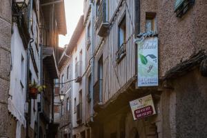 a narrow alley with buildings and a sign for a restaurant at Hostal La Balsá in La Alberca