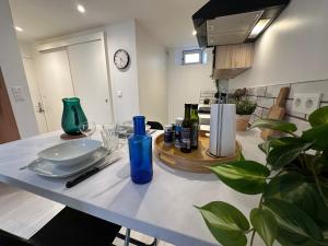 a table with a plate and bottles on it in a kitchen at Le Cabrol Grand studio Hyper centre WIFI 2ème étage in Rodez +10 photos