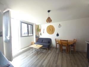 a living room with a blue couch and a table at Le cosy in Clermont-lʼHérault