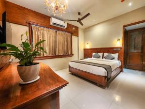 a bedroom with a bed and a potted plant at The Falcon Inn - Clare Road in Mumbai