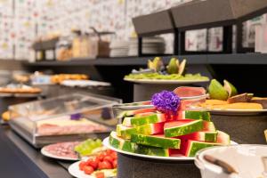 a buffet line with plates of fruits and vegetables at Astoria Guest House in Ravenna