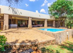 an exterior view of a house with a swimming pool at Elements Bush Villa 216 in Moheme