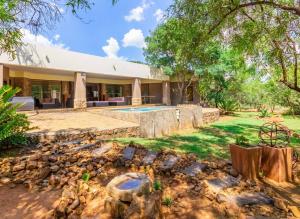 an exterior view of a house with a yard at Elements Bush Villa 216 in Moheme