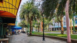 a street with palm trees and a sidewalk with a building at The Star hotel DTH3-31 in Phú Quốc