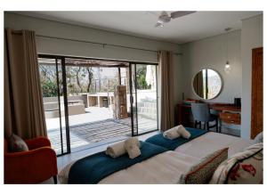 a bedroom with a large bed and a large window at Elements Private Golf Villa 295 in Warmbaths +68 photos