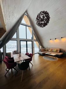 a living room with a table and a couch at Mokki - A-frame cozy în Apuseni in Mărişel