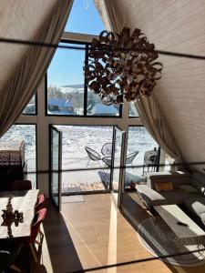 a chandelier in a room with a view of the water at Mokki - A-frame cozy în Apuseni in Mărişel +64 photos