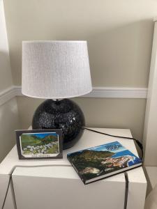 a table with a lamp and two pictures on it at Modern room (with deck) in Povoação