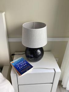 a lamp and a book on a nightstand with a bed at Modern room (with deck) in Povoação