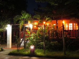 a house with lights in the yard at night at Happiness Resort Sukhothai in Sukhothai