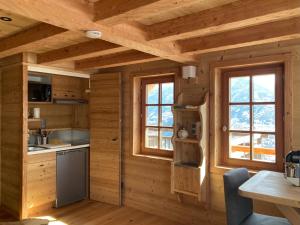 a kitchen in a log cabin with two windows at Vertigo in Puy-Saint-Pierre