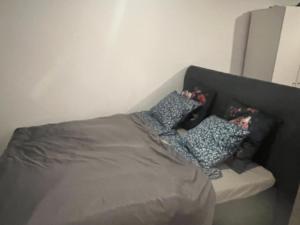 a bed with two pillows on top of it at Cozy home in between Malmö & Lund in Åkarp