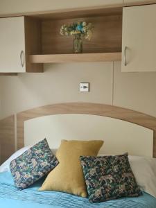 a bed with two pillows and a vase on top at Ruth's Rest Shropshire Country Retreat with private Hot Tub & Views countryside in Shrewsbury