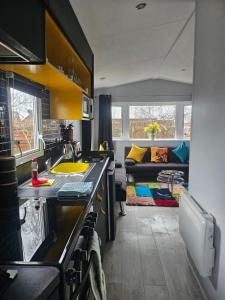 a kitchen with a sink and a living room at Ruth's Rest Shropshire Country Retreat with private Hot Tub & Views countryside in Shrewsbury