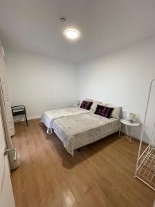 a white bedroom with a bed and a table at Apartamento Pla in Girona