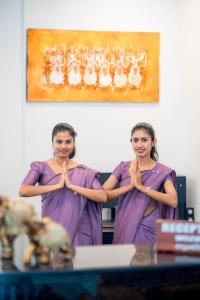 two women in purple robes are performing aorativeorativeorativeorativelicationlicationlicationlication at Lavendish Wild Safari in Wasgamuwa