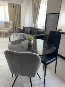 a living room with a glass table and chairs at Apartament A&Maya in Râmnicu Vâlcea