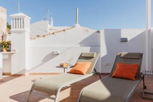 a balcony with two chairs and a table at Laranjal Rive Gauche in Tavira