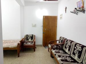 a living room with a couch and a chair at Alice's Cozy Abode in Udupi