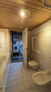 a bathroom with a toilet and a sink and a washing machine at Válur Cozy Cottage in Válur +36 photos
